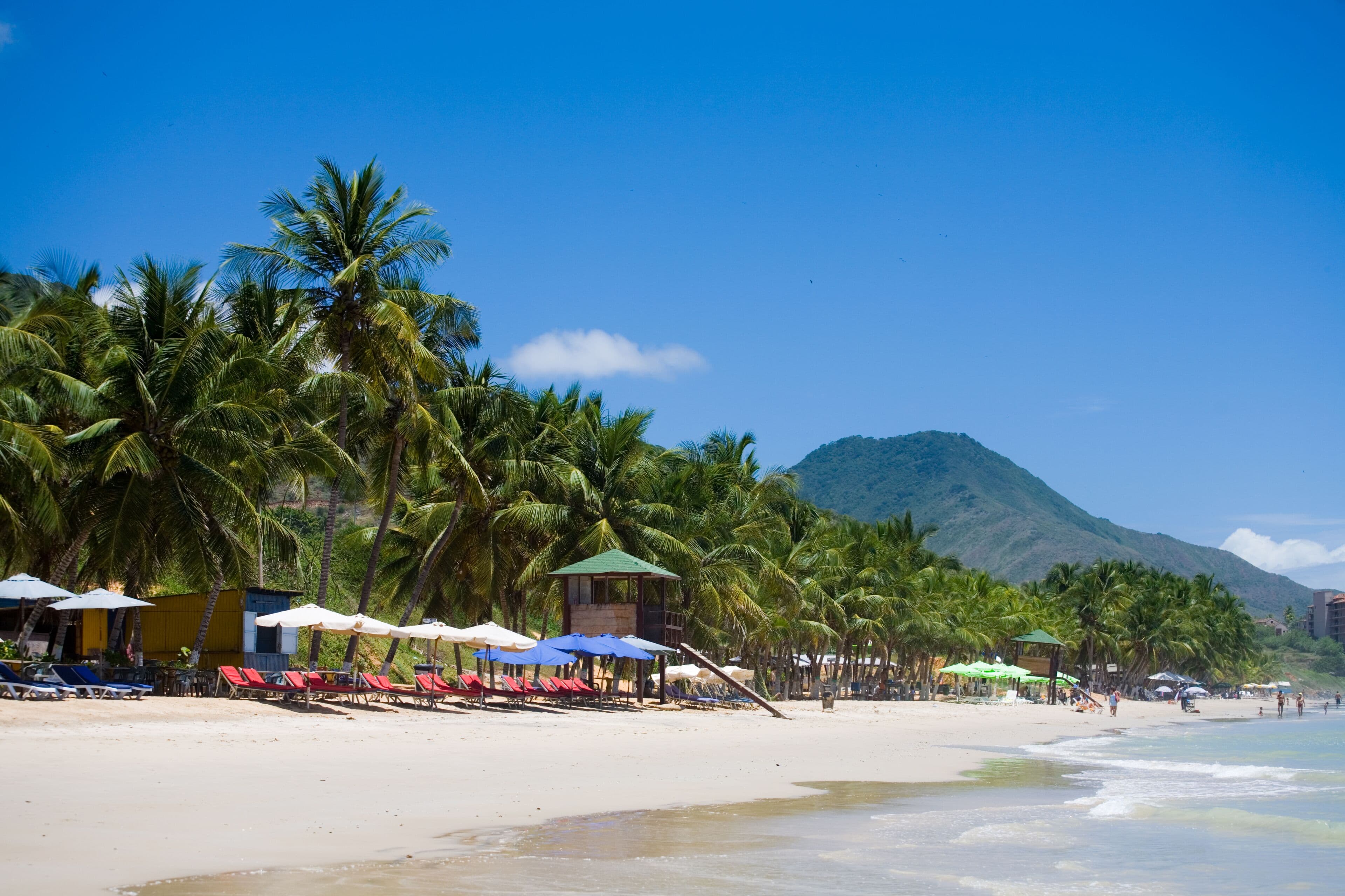 Playa con palmeras y casetas de salvavidas en Margarita